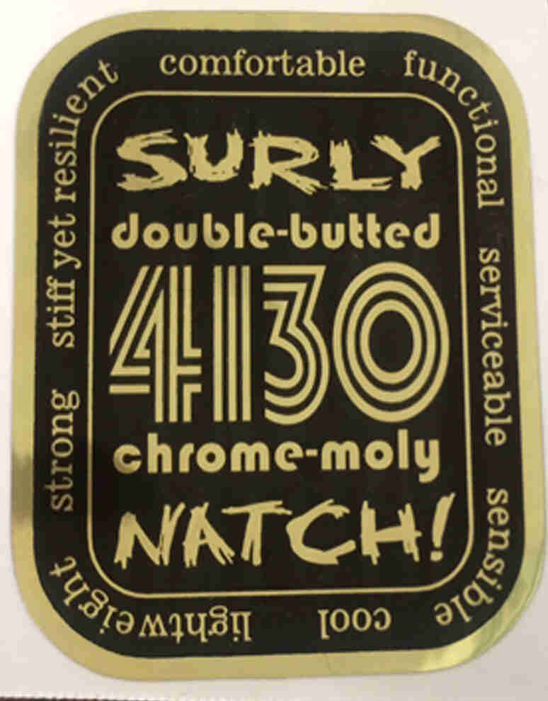 A Surly double-butted-4130-chrome-moly-Natch! adhesive sticker - black background with gold writing