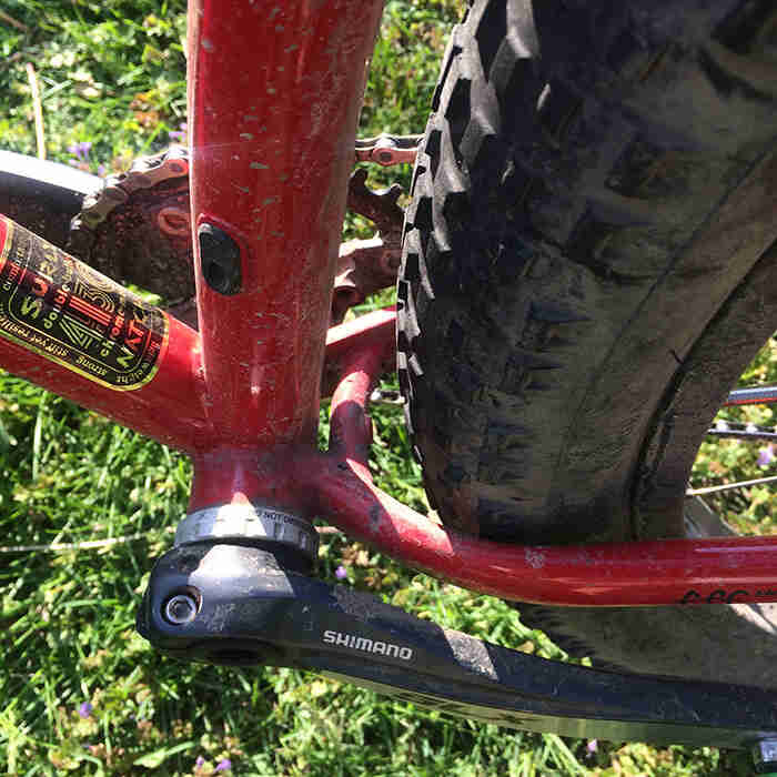 Close up view of the left crank arm, chainstay and seat tube of a Surly Krampus bike, red