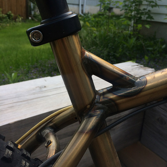 Close up view of the seat tube and seat clamp on a Surly Krampus bike, gold