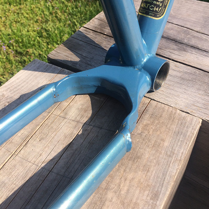 Close up view of the two-piece welded sheet metal yoke on a prototype Krampus bike frame, blue