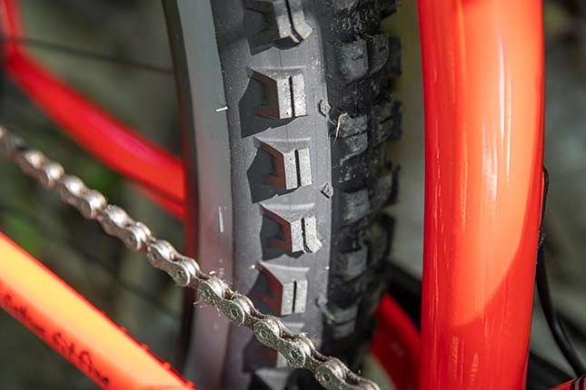 Close-up of rear Surly Dirt Wizard tire lugs with siping on red/orange Surly bike