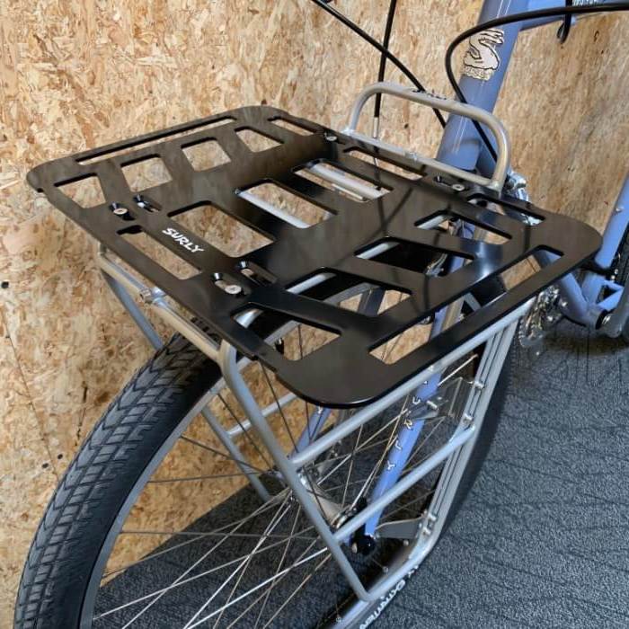 Surly TV Tray front rack, black, mounted to a Surly bike in front of an OSB wood wall
