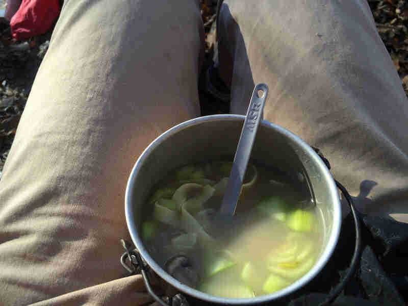 Downward view of a bowl of soup on a person's lap