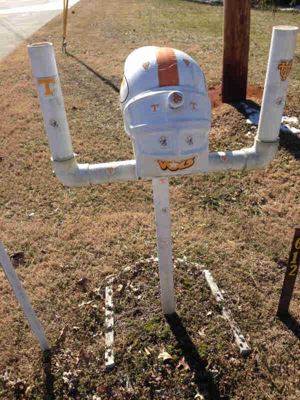 Front view of a mailbox made to look like a University of Tennessee football helmet sitting between a goal post 