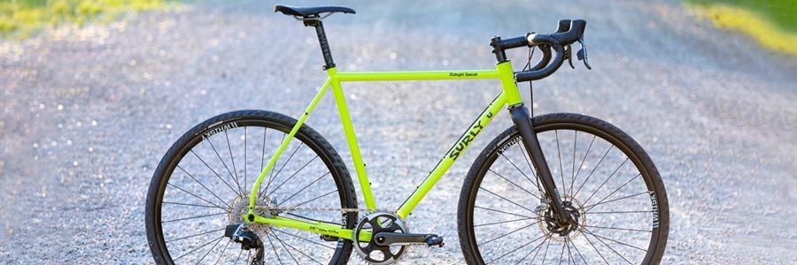 Custom Surly Midnight Special bike, lime green color, side view propped up on gravel road
