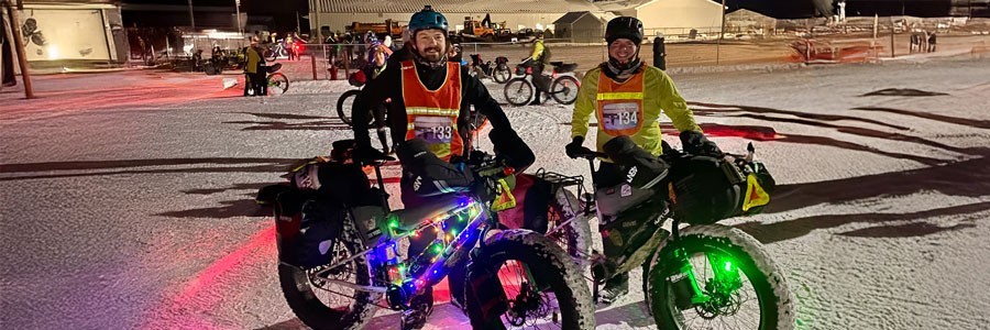 Price brothers standing together with loaded Surly Moonlander fat bikes at Arrowhead 135 start