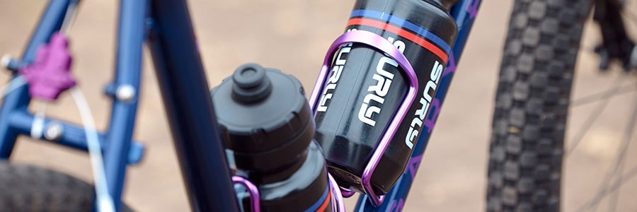 Close-up of purple annodized water bottle cages on HooKooEKoo frame with Surly Intergalactic waterbottles