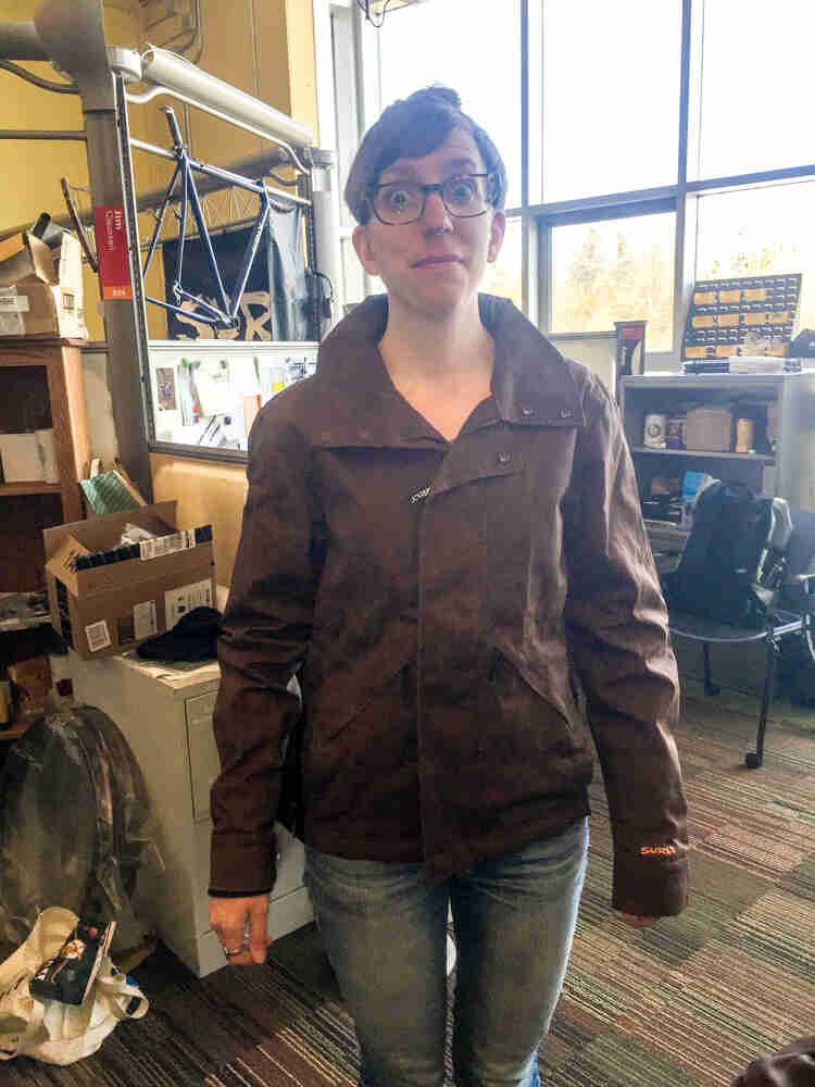 Front view of Amy wear a Surly Waxed Jacket 2.0 in an office setting