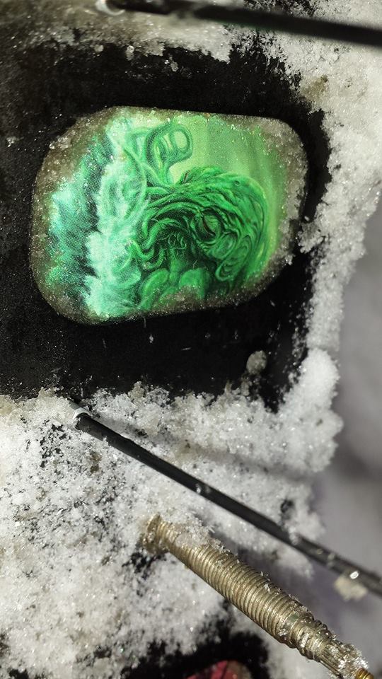 A zoomed in image of a fat bike rim with snow on it, with a green octopus on the rim tape