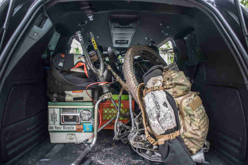 Rear view of the back of a van loaded with a bike and gear