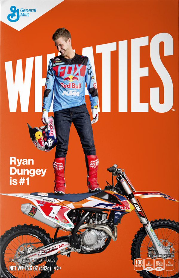 A Wheaties cereal box cover with a motocross rider standing on the seat of a motorcycle