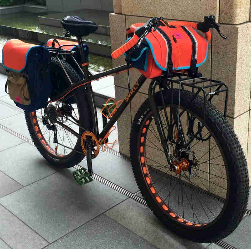 A Surly ECR bike - black - parked against a cement block pillar - right side view