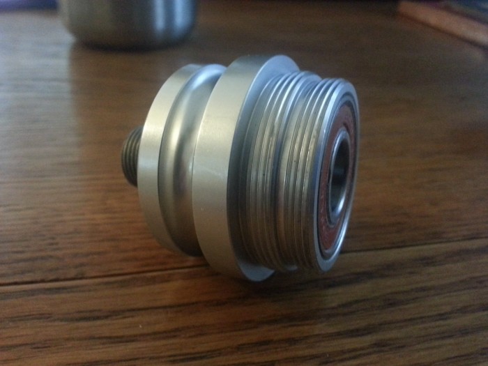 Straight on view of a Surly Fixxer rear bike hub, set on a wood table