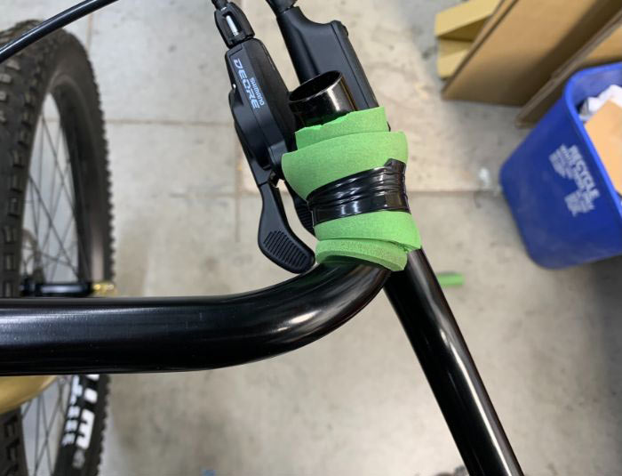 Top-down view of Corner Bar mounted on bike with cut up green grip taped onto the hood position of bar