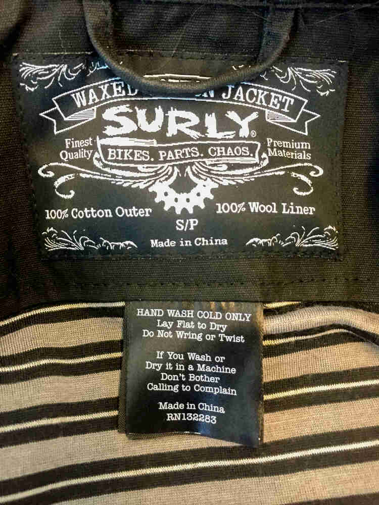 Inside collar tag and care instructions, sewn into a Surly Waxed Jacket 2.0 - closed up view