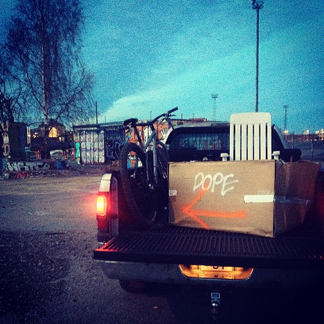 Rear view of a pick up truck with a Surly Karate Monkey bike and cardboard box in the bed