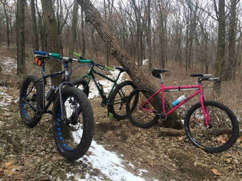Surly brand Pugsley fat bike, Krampus bike and 1x1 bike, parked around a snowy trail in the bare woods