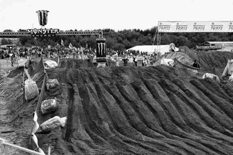 Straight away view of a dirt motocross track with deep parallel grooves on the hills - black & white image