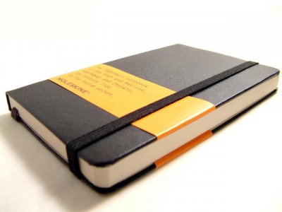 A Mole Skin hardbound writing journal  - black and yellow - white background - flat, angled front view