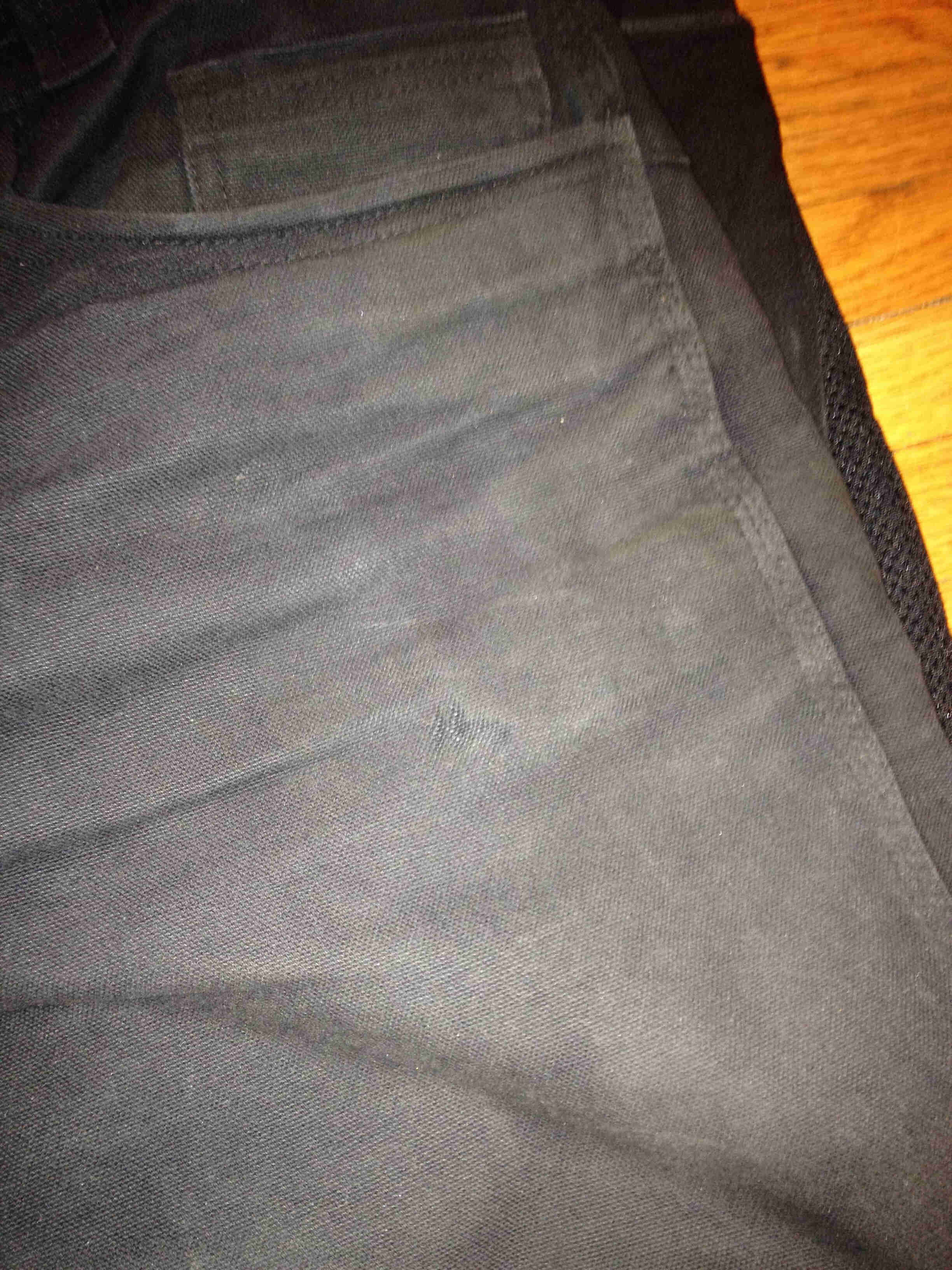 Downward, front, upper left side view of a pair of black Surly pants