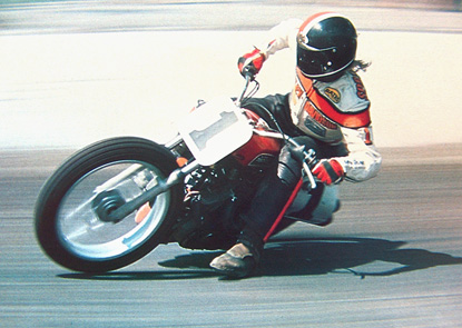 A racing motorcycle rider skidding around a corner on a racetrack