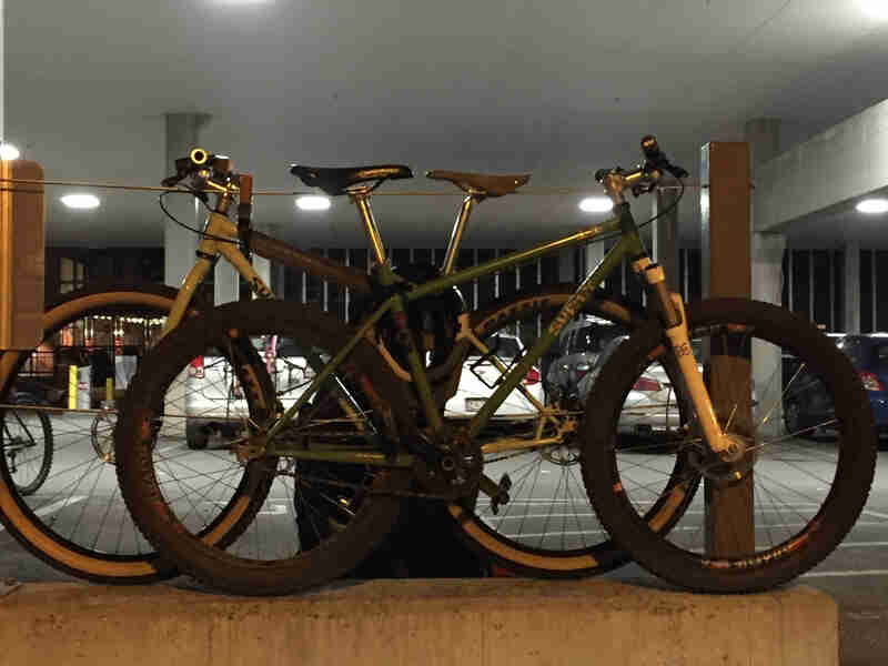 Side view of two Surly bikes, with one in front of the other, facing opposite directions, in a parking garage