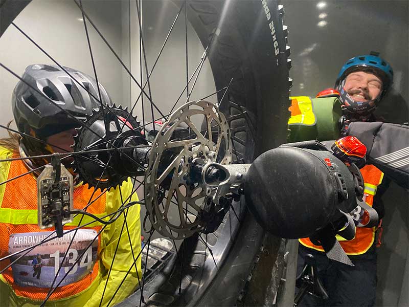 Price brothers in winter riding gear crammed in elevator with Surly Moonlander bikes loaded 