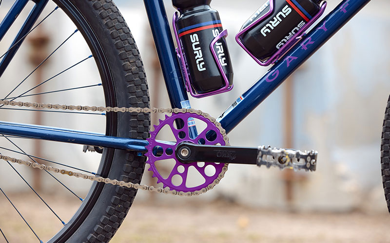 Detail of purple annodized water bottle cages on seat tube and down tube