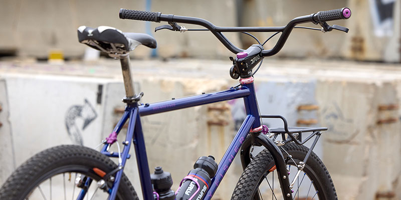 Rear three-quarter view of custom bike build outside focus on stem and handlebars